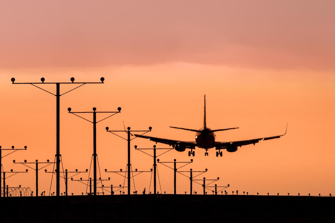 A Boeing 737 touching down at sunset