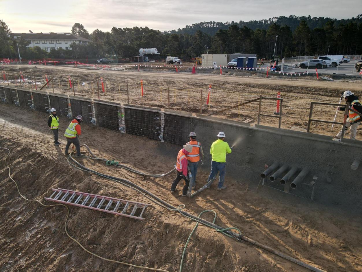 Workers spray concrete to secure the southern base of the terminal.