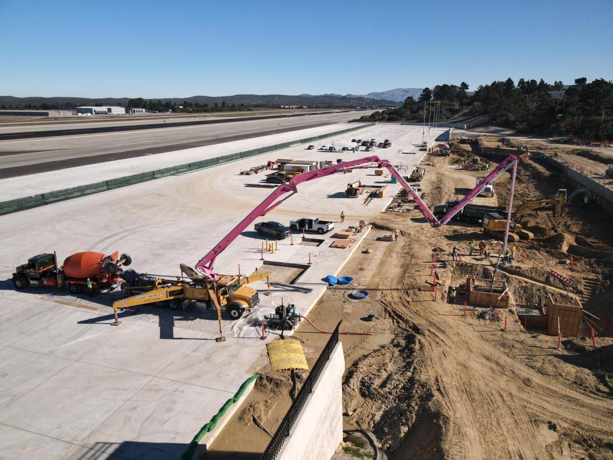 Eastward view of workers laying concrete for the service elevator pit.