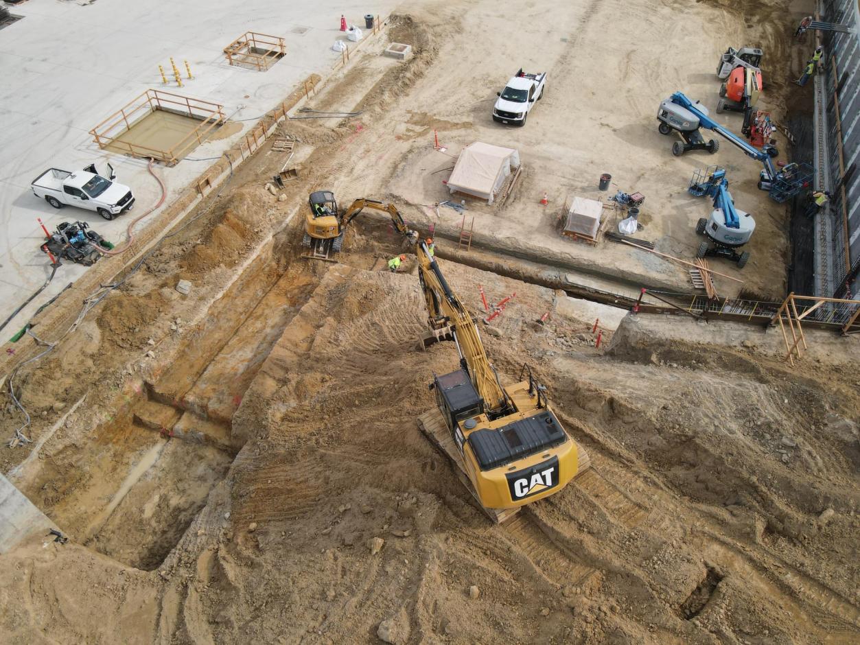 Excavators dig out a pit for the western terminal perimeter wall footing.