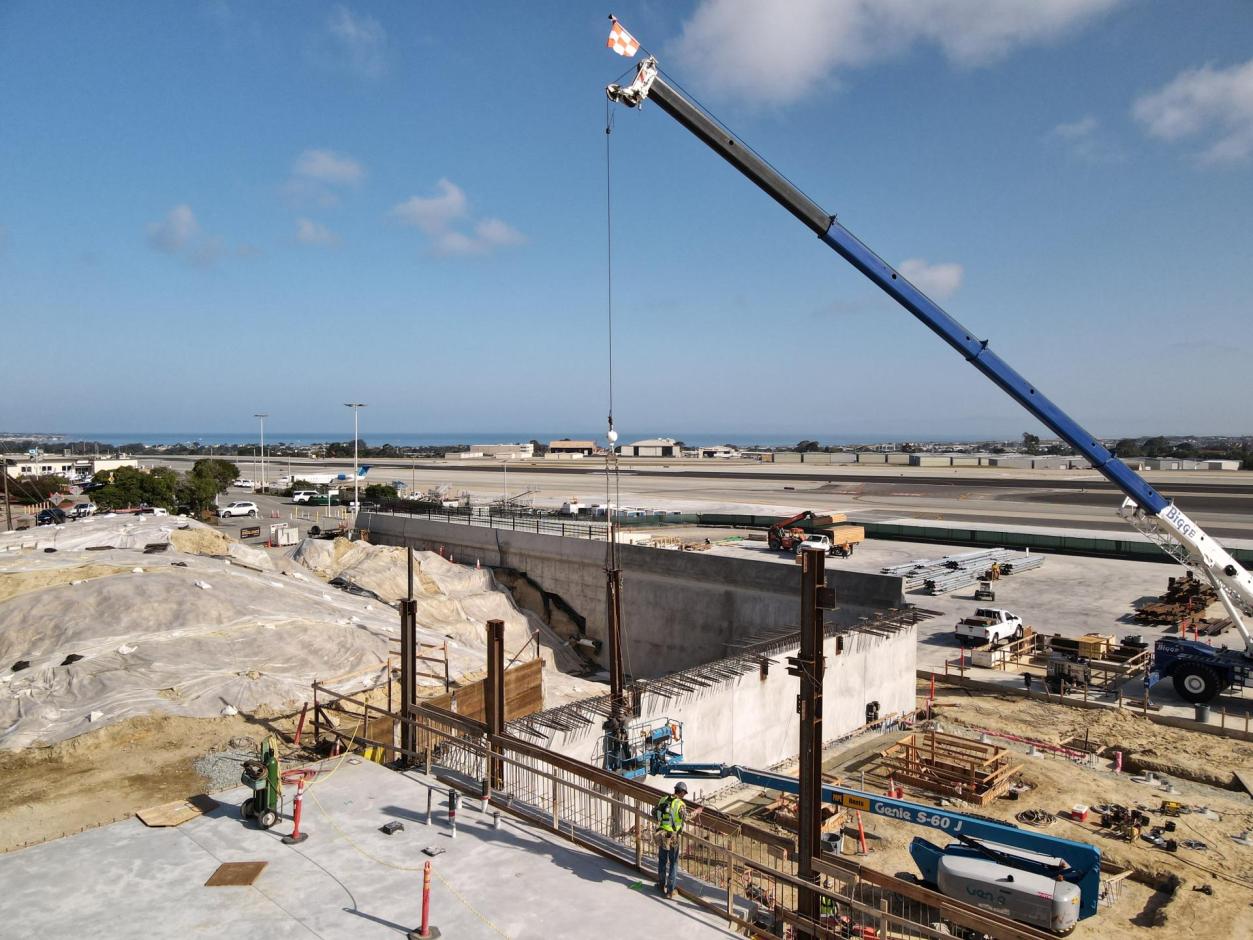 Ironworkers help the crane operator guide the steel columns into place.