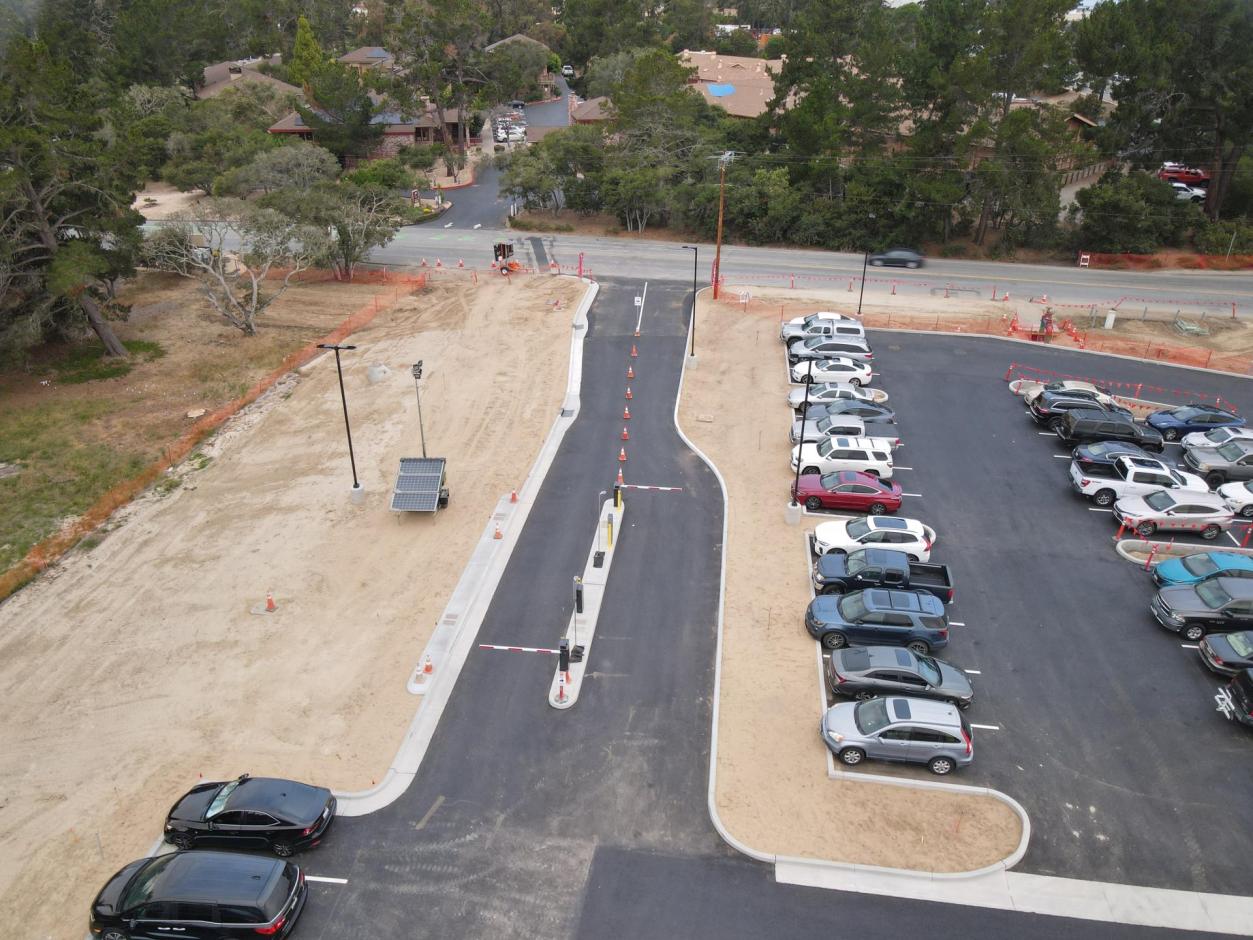 The new Entrance (temporary) and exit lane to the long term lot.  The entrances features a modern Parking Access and Revenue Control System (PARCS),  with contactless payment and remote, back-end  management.