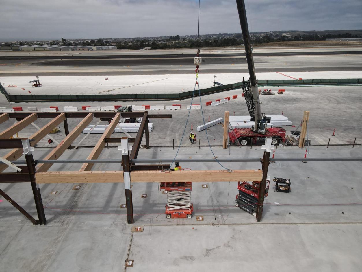 A Biggie Crane lowers a mass timber beam into place.