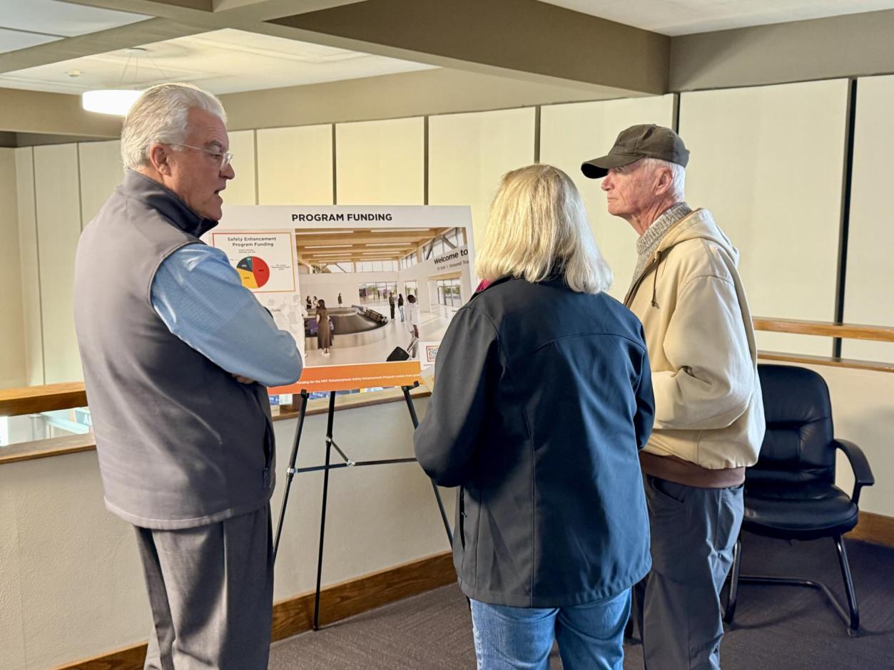Three individuals discussing Program Funding for the Metamorphosis project.
