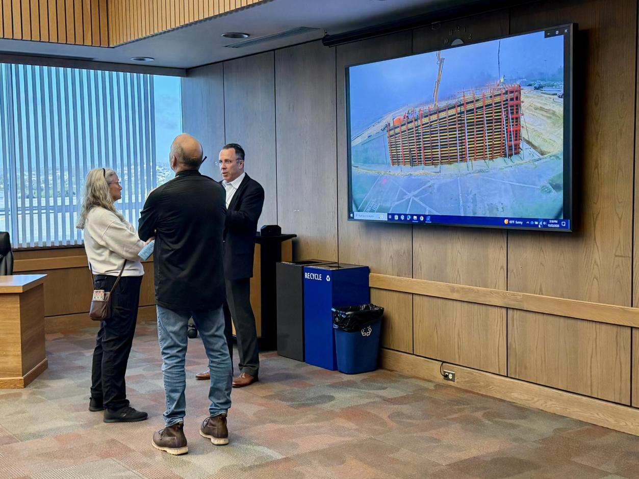 Three individuals discussing the progress on the terminal apron.
