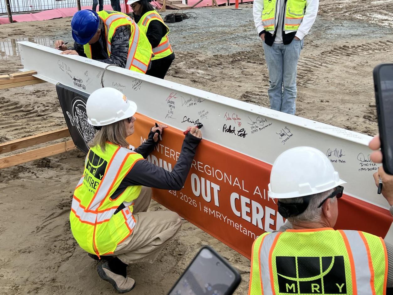 Chris Morello, MRY's Executive Director, leaves her signature on the beam.