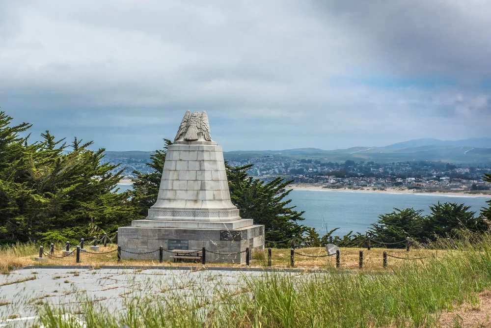The Sloat Monument near the Monterey Presidio with a view of the bay in the background.