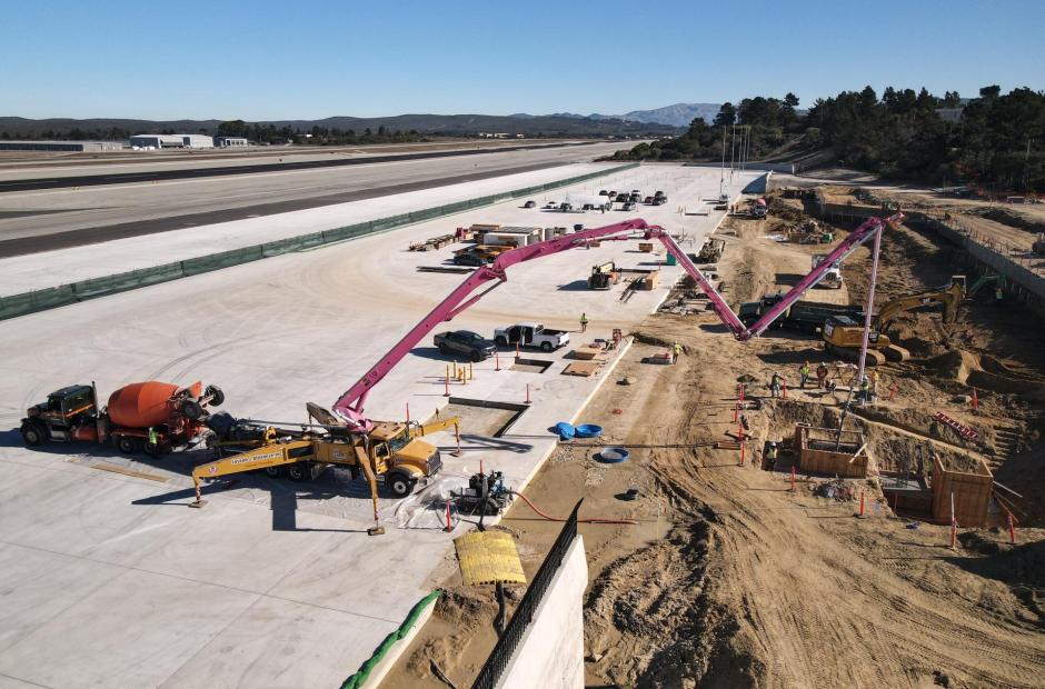 Eastward view of workers laying concrete for the service elevator pit.