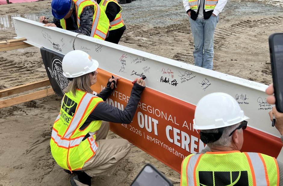 Chris Morello, MRY's Executive Director, leaves her signature on the beam.