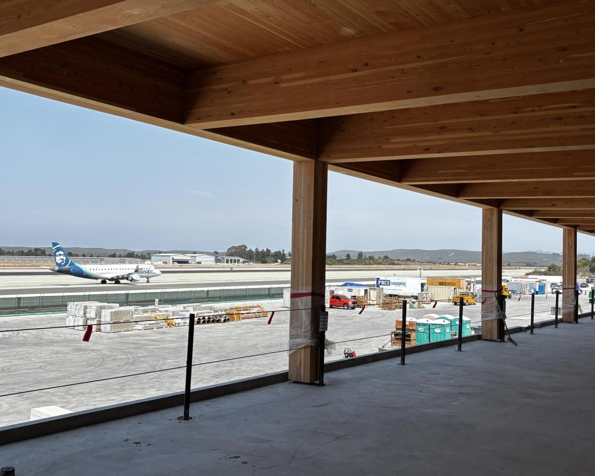 An Alaska Airlines departure taxis by the Replacement Terminal, which is set to open in summer of 2027.